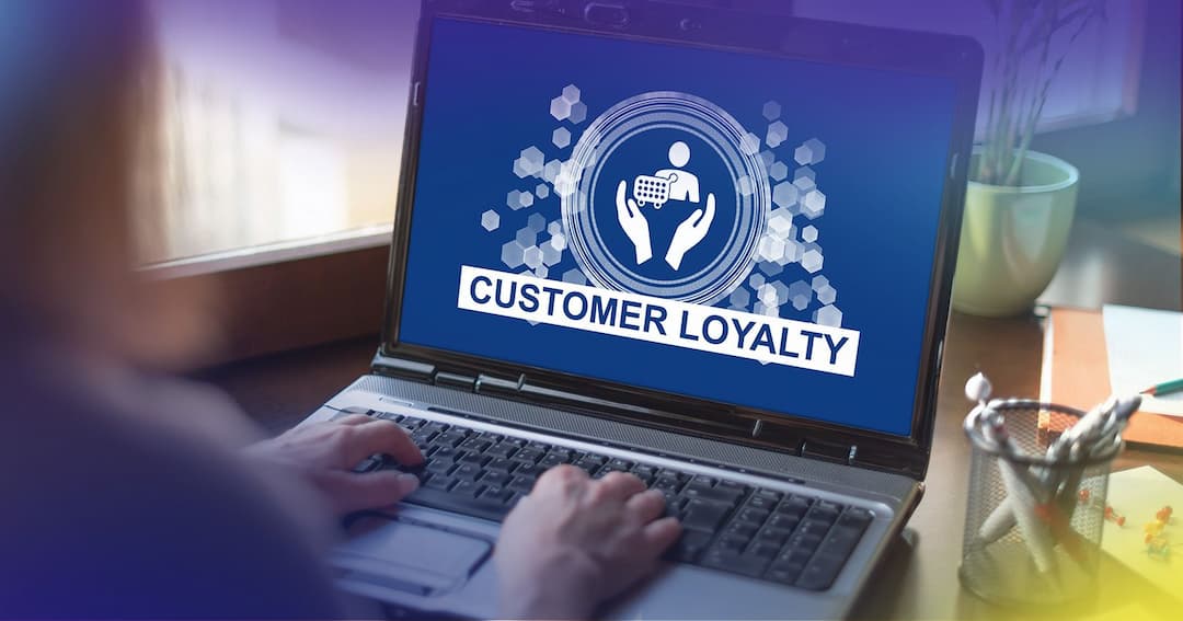 Woman's hands on laptop with graphic on screen that reads "Customer Loyalty."